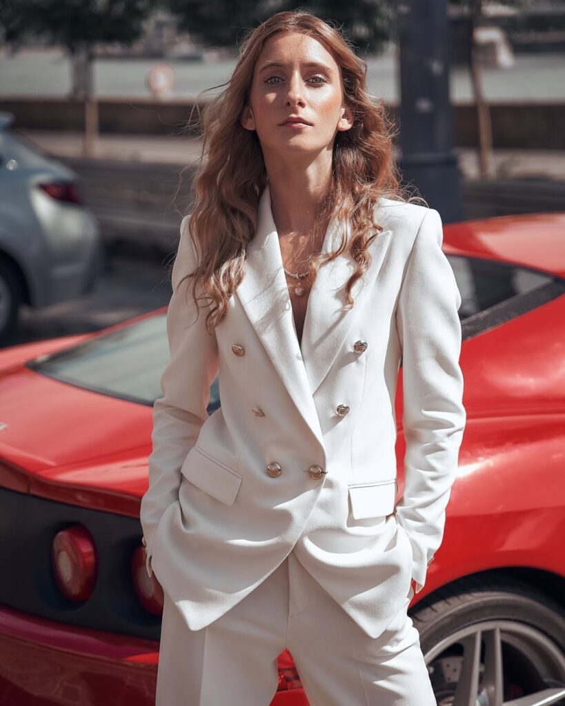 Fashion portrait in a white suit with a red sports car by ShotsByDeen
